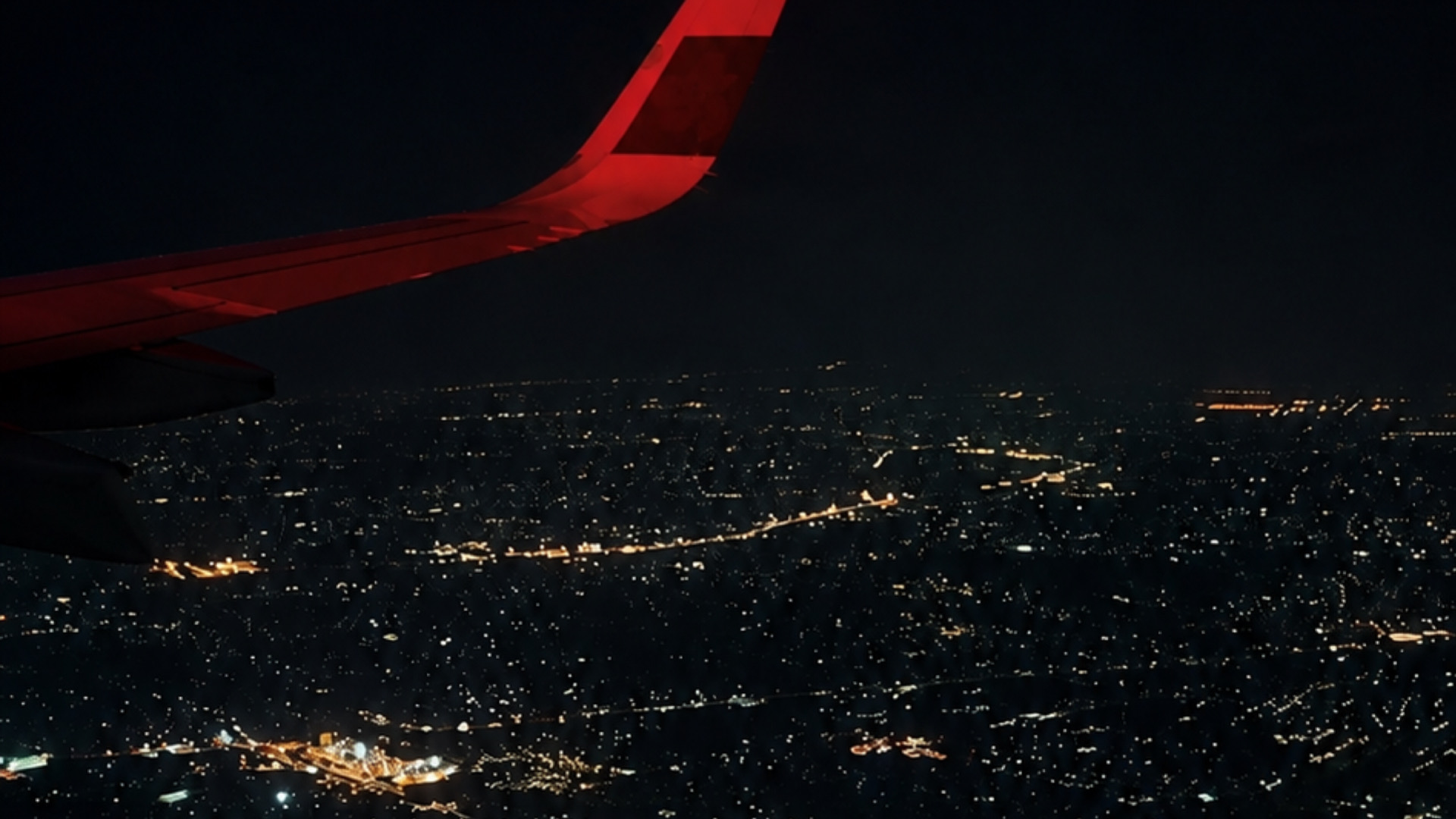 ⁠日本とフィリピンを結ぶ国際線フライトの翼と夜景⁠
